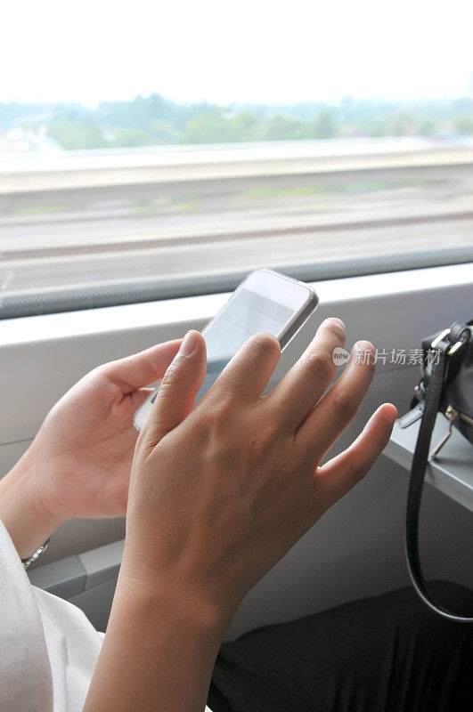 中国女子在高铁上握着手机