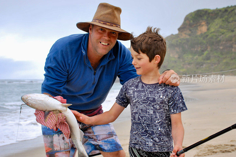一个男孩与他的父亲和他的鱼合影