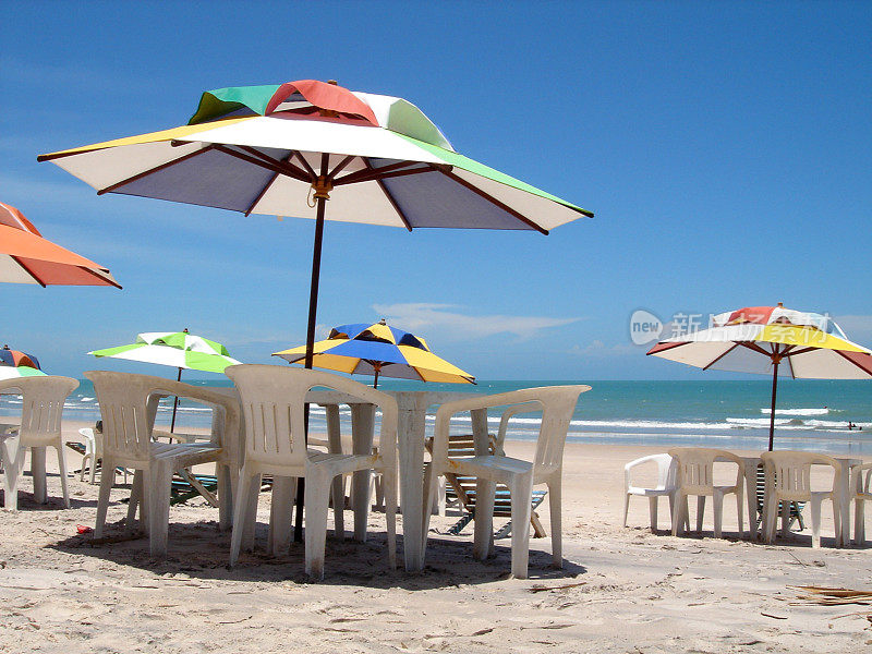 沙滩上五颜六色的阳伞和樱桃等着客户