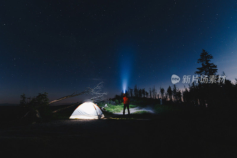 晚上在帐篷附近拿着手电筒的游客