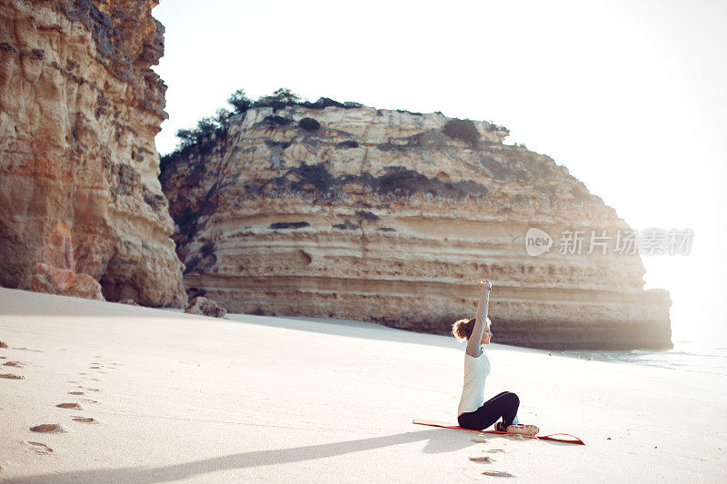 在海边做瑜伽的年轻女子