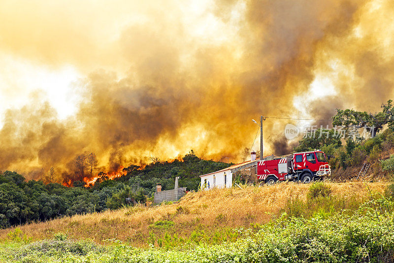葡萄牙一所乡村房屋和消防车附近发生森林火灾