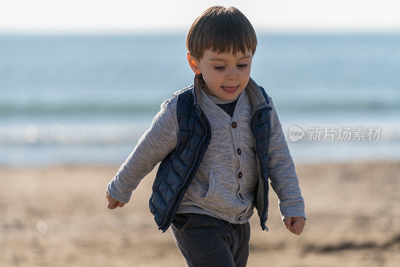 小男孩在海滩上跑步