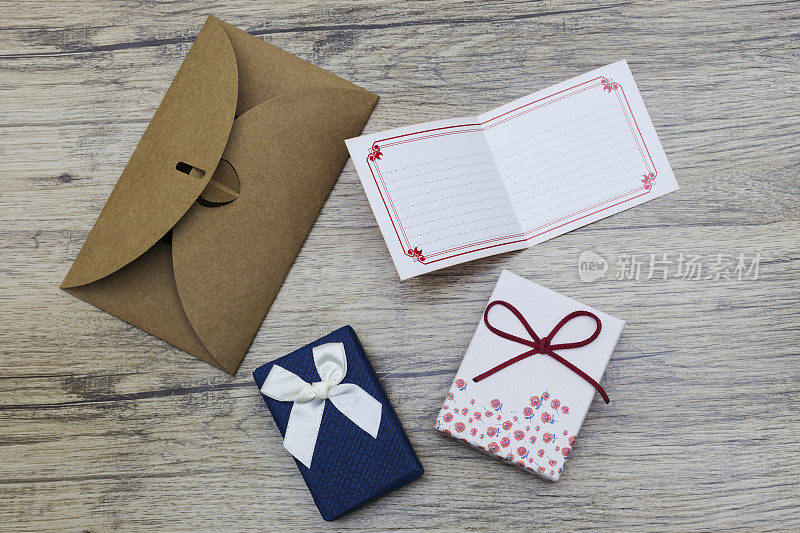 空白纸卡与棕色信封和手工礼品盒上的木头。