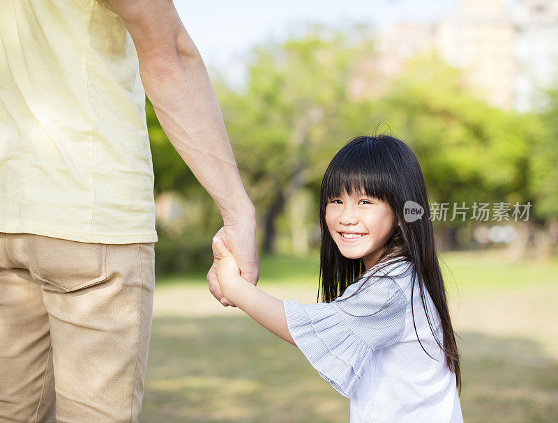 父亲牵着小女孩的手