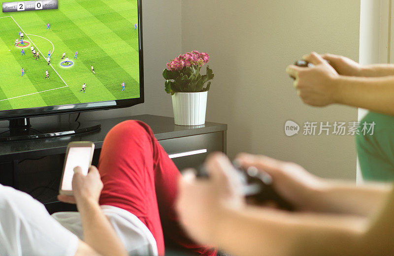 一群朋友在外面玩虚拟的足球或足球视频游戏。