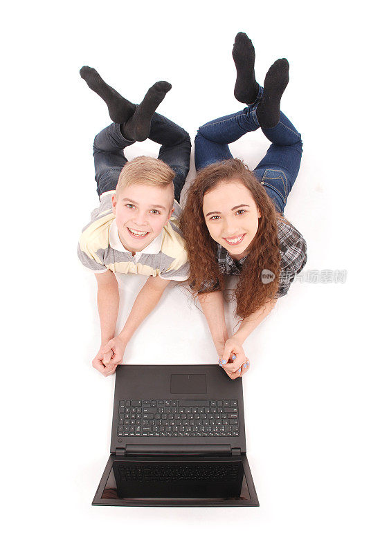 男孩和女孩躺在地板上用笔记本电脑