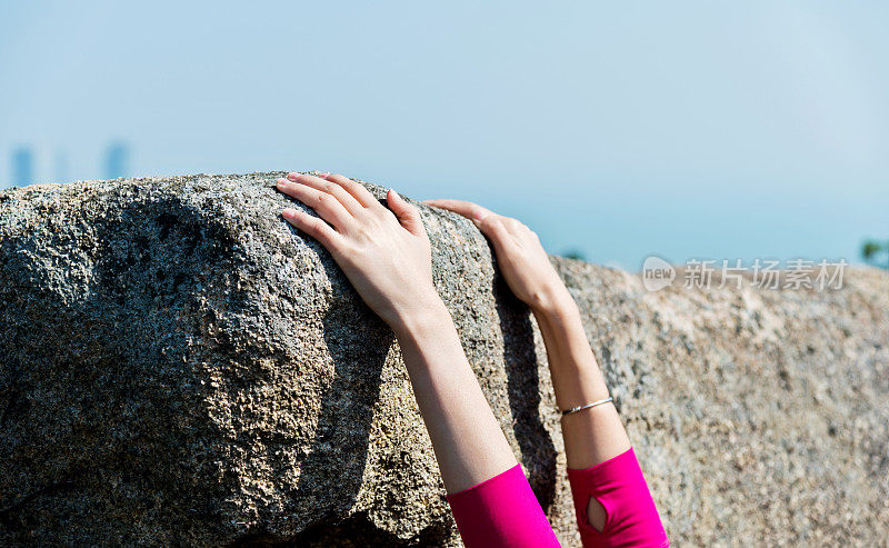 女人的手在岩石的边缘