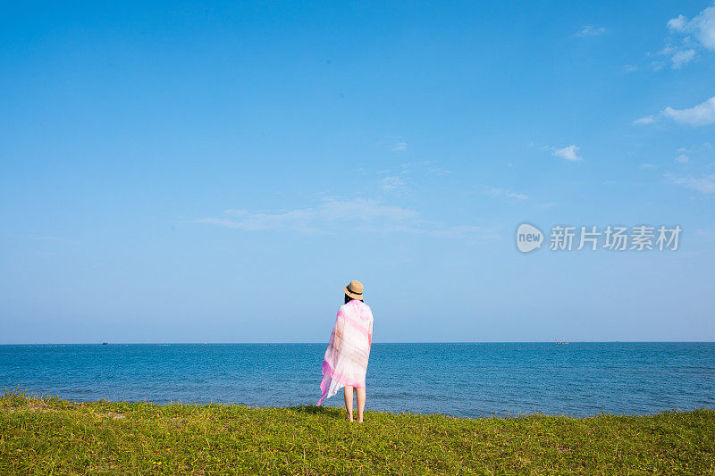 年轻女子站在海岸上