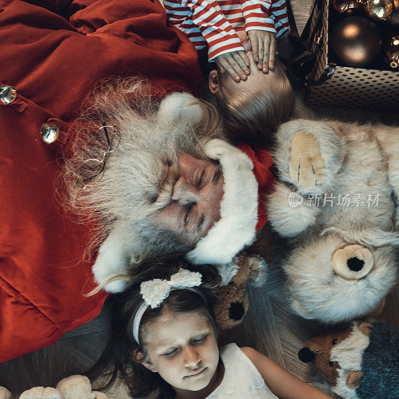 女孩，男孩和圣诞老人躺在地板上