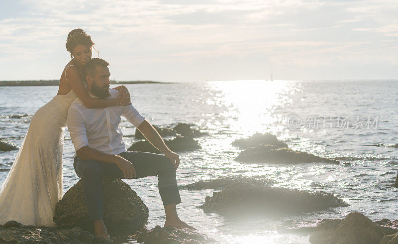 日落时分，一对年轻夫妇在海滩上。