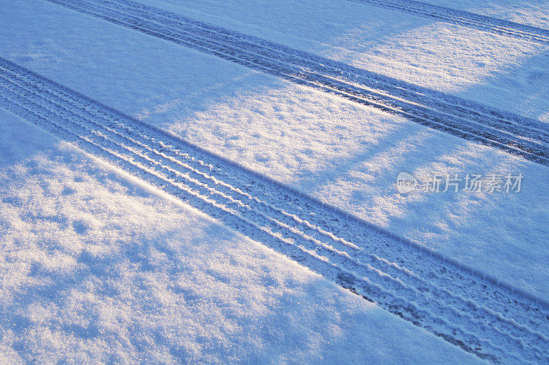 黎明时分雪地上的汽车轮胎印