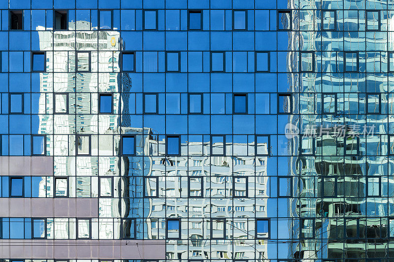 在华沙市中心的现代建筑中映照出一幢玻璃幕墙的摩天大楼