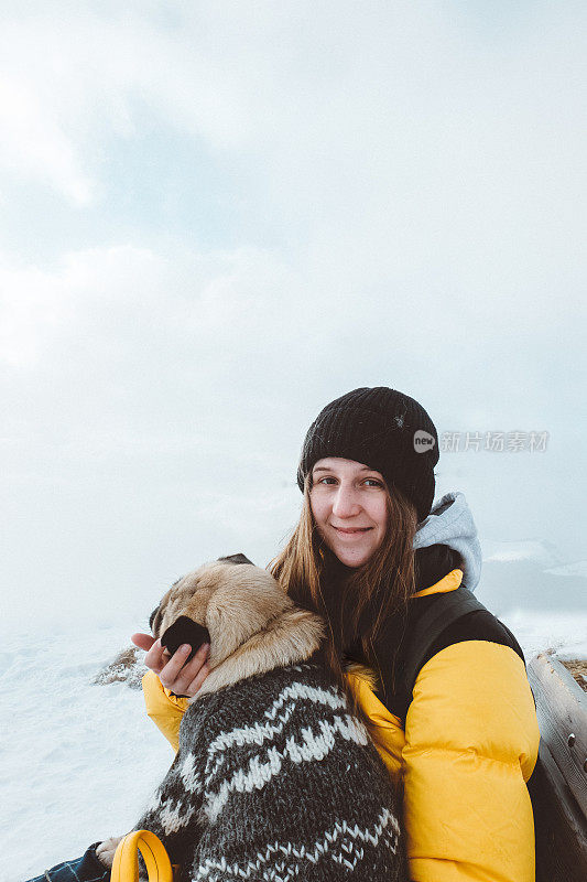 一名妇女和一只狗在冬季徒步旅行到意大利多洛米特的塞塞达山