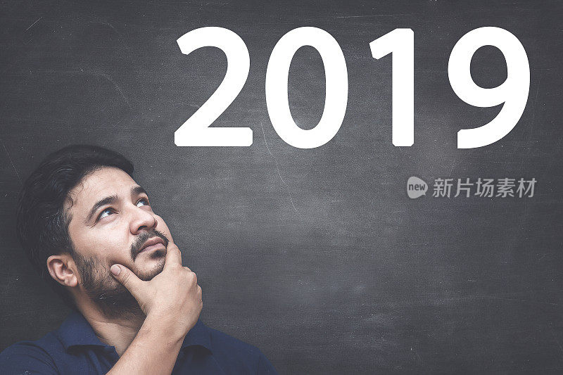 男人在黑板上看2019年新年决心