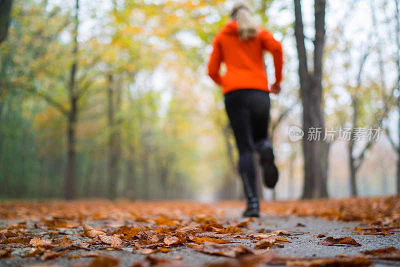 模糊的慢跑的女人在公园聚焦前景