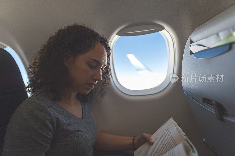 女旅行者在飞机上看书