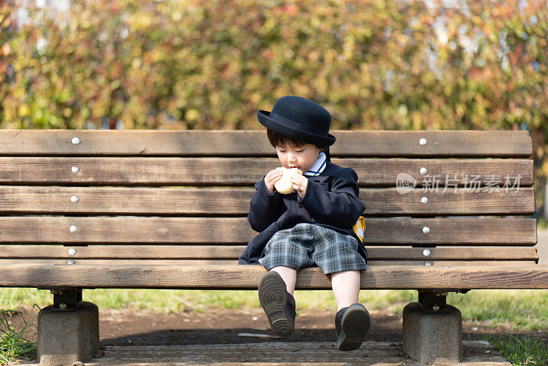 幼儿在长凳上吃面包