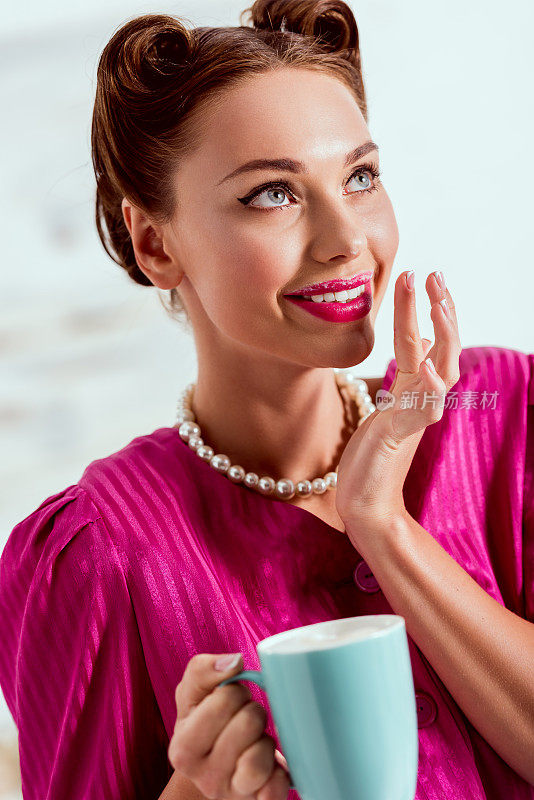 漂亮的姑娘拿着一杯咖啡，手捧在嘴边