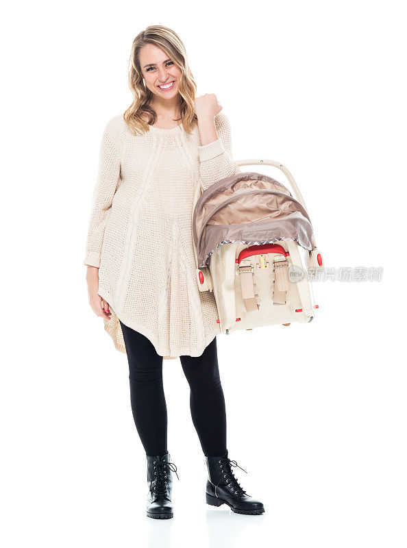 年轻漂亮的妈妈穿着一件毛衣抱着一个婴儿汽车座椅-微笑