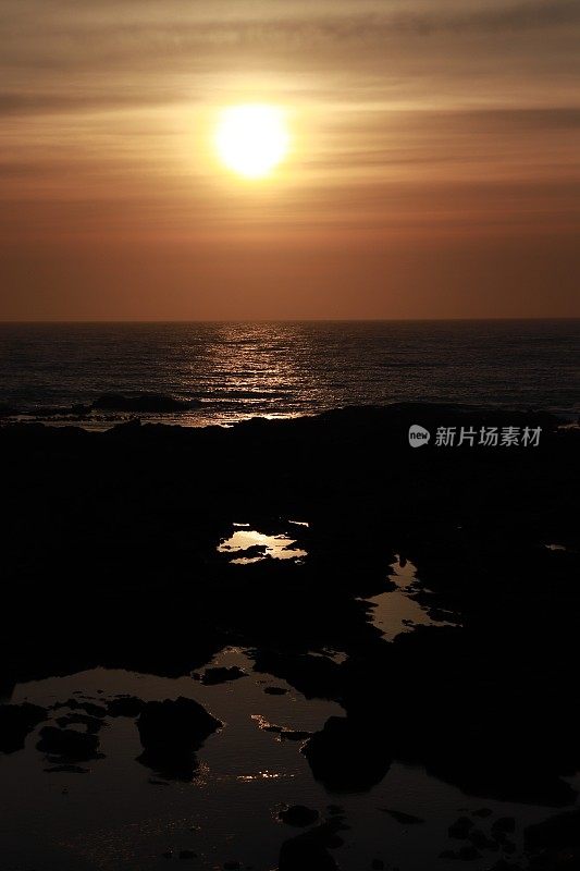 日出越过岩石和大海