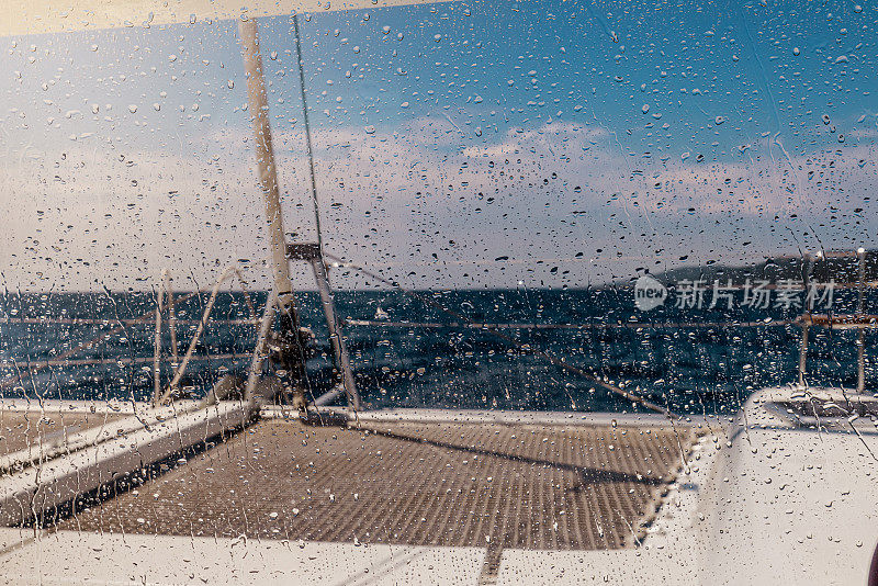 裁剪图像的船甲板对天空看到从湿玻璃窗