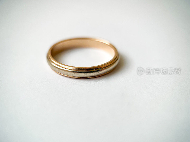 金色结婚戒指，白色背景。红白相间的金戒指