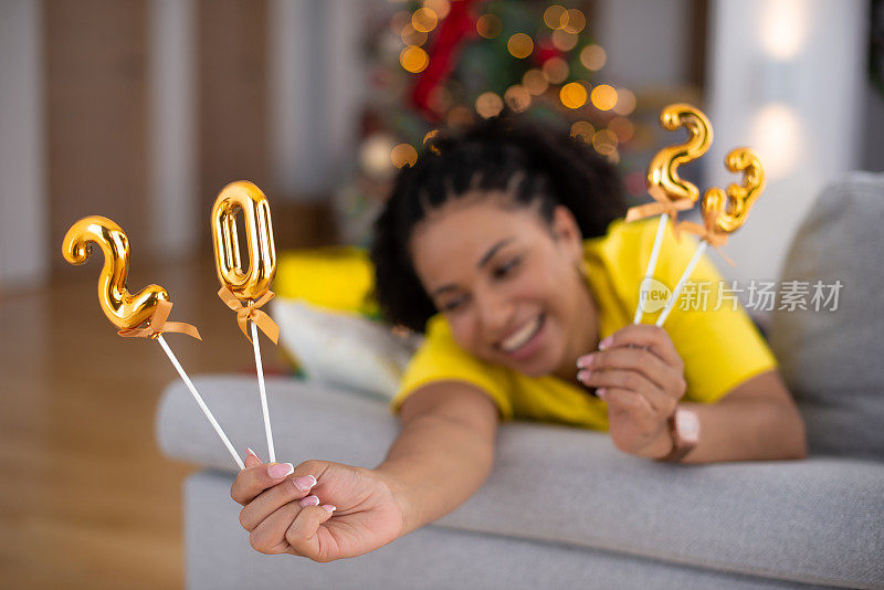 快乐的女人在家里庆祝新年库存照片