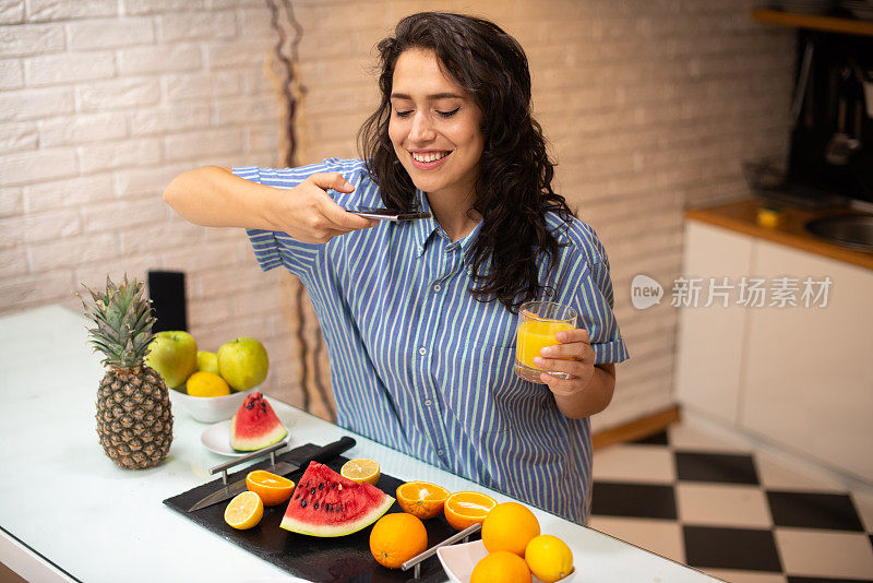 美丽的肖像年轻女子在厨房吃早餐库存照片