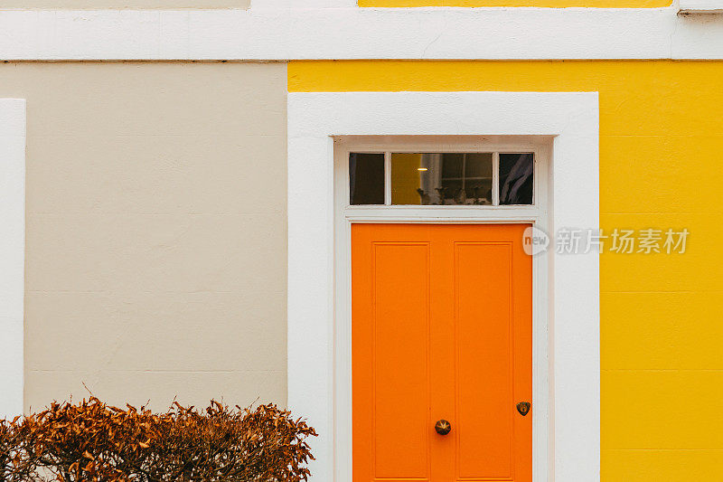 城市街道上的住宅橙色前门和黄色立面