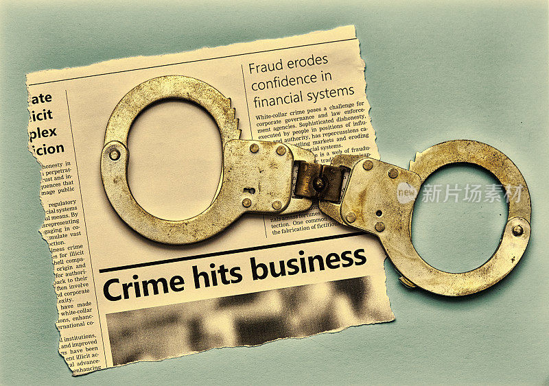 报纸上一篇关于商业犯罪的文章，用手铐代表警察、司法和执法