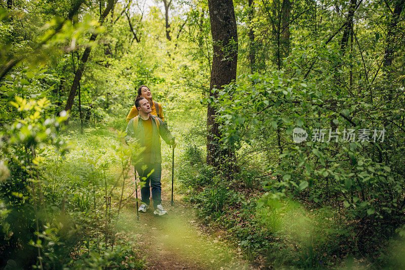 两个朋友，一个年轻的女人和一个患有唐氏综合症的男人，一起在森林里远足