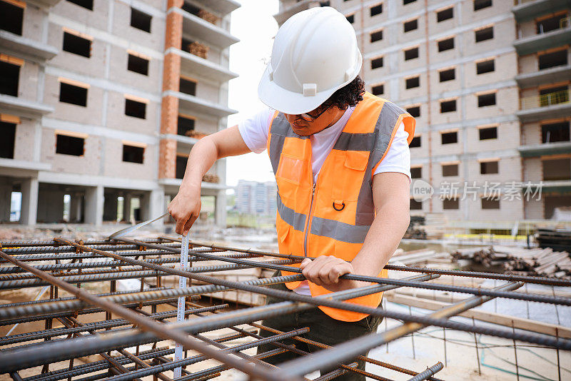 男工程师拿着文件自信地站在施工现场