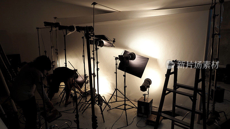 摄影棚内的灯光设置，用于商业作品，如照片电影或视频电影制作，使用许多1000瓦以上的LED灯，带有大软箱，防喷反射伞和三脚架。