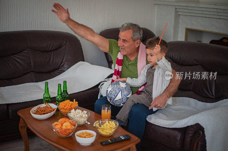 球迷们正在看电视，爷爷和孙子