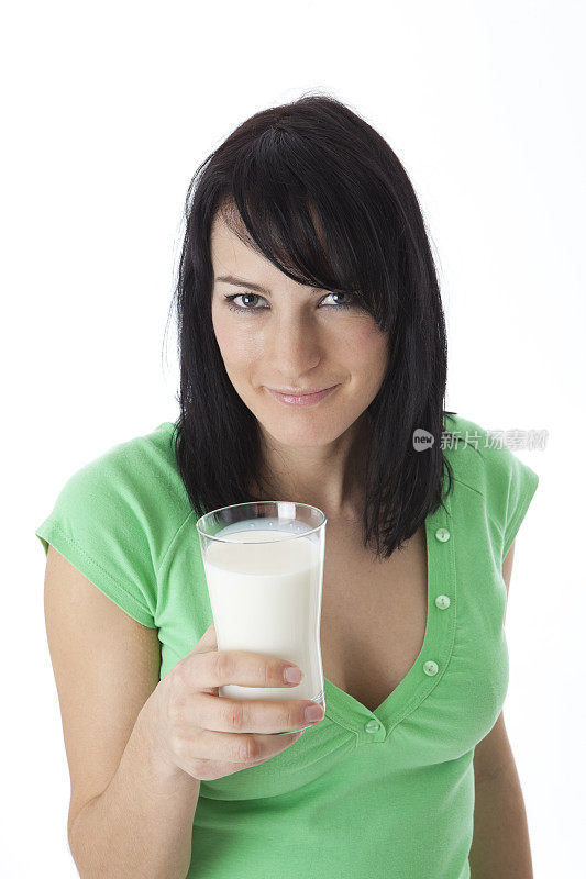 拿着一杯新鲜牛奶的年轻女子