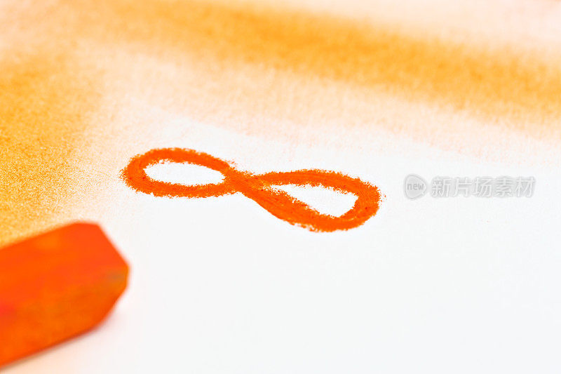 无限符号用橙色蜡笔在白色上画