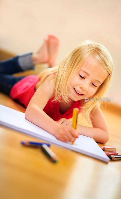 快乐的女孩正在纸上创造性的画画