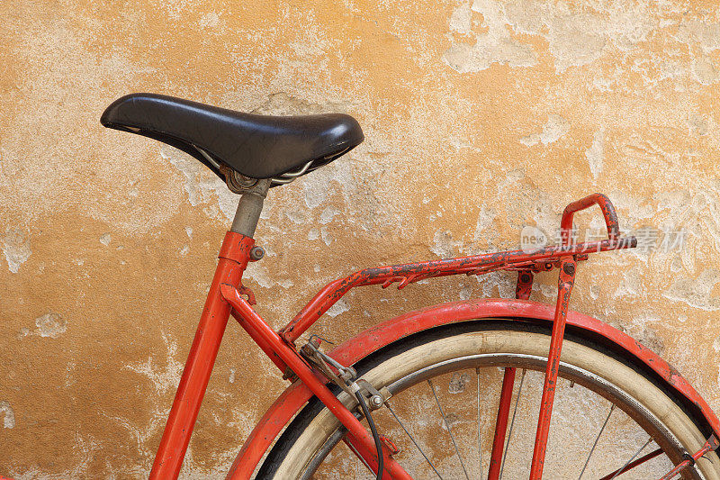 意大利卢卡托斯卡纳的旧红色自行车靠在黄色的墙上