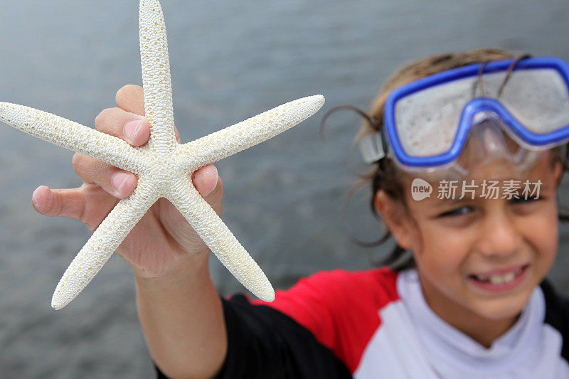 家庭度假时微笑的孩子抱着海星