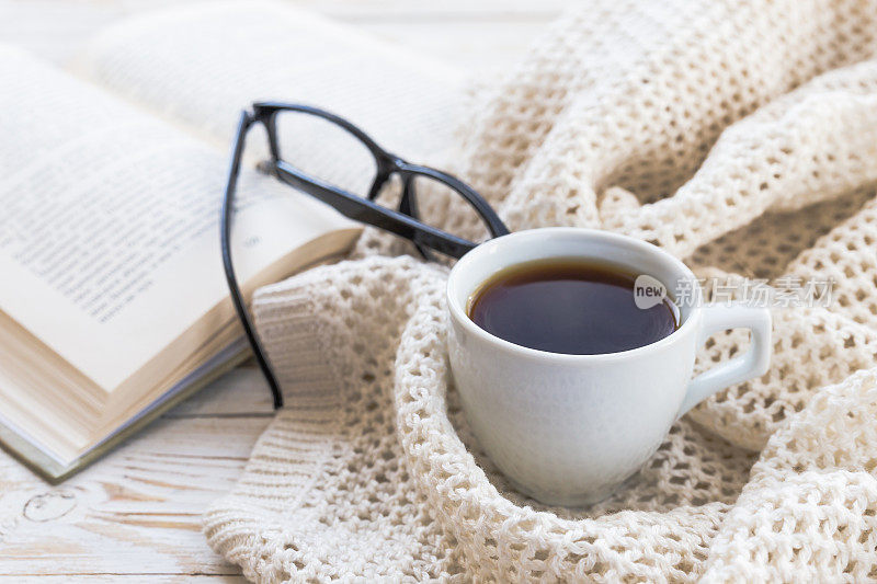 温暖的针织格子，眼镜，一杯热咖啡和一本书