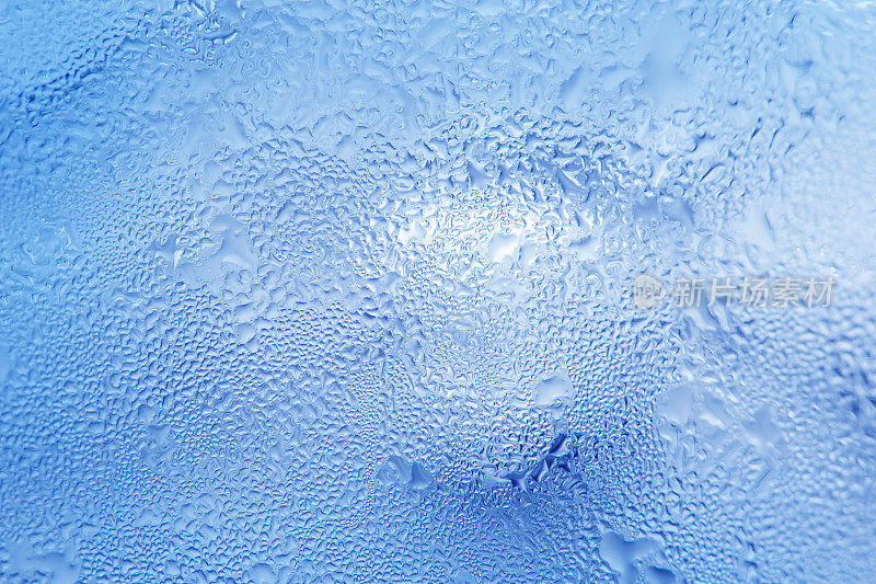 冰冻的水滴在冰冷的冰玻璃上