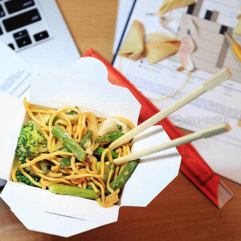 桌上放着中餐盒。在办公室吃饭。加班的概念。