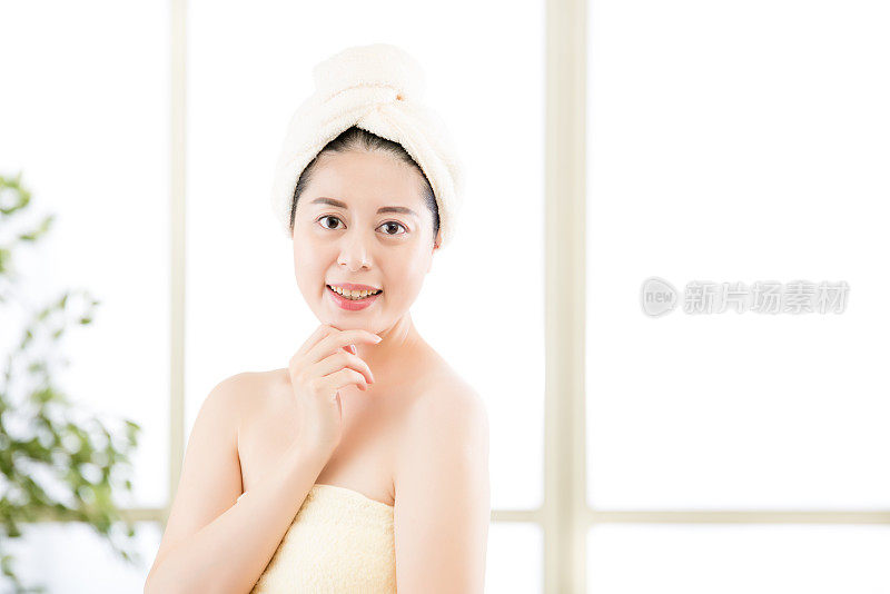 迷人的亚洲女人在淋浴后在头上烘干毛巾