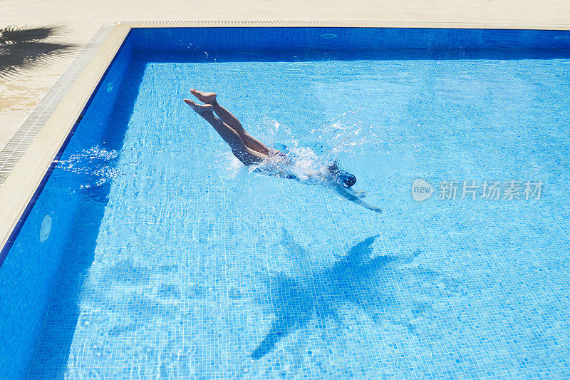年轻女子在游泳池里游泳