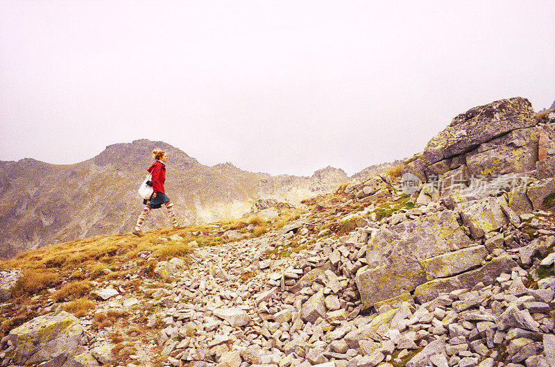 在瑞拉山的一块岩石上行走的女人