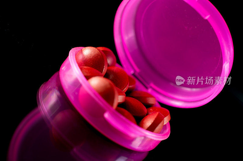 粉红色药丸容器与药丸