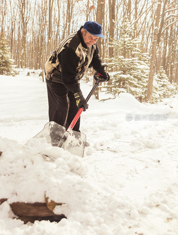 老人在清扫门前的积雪