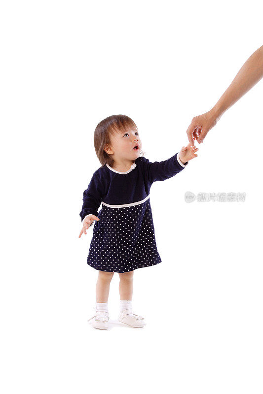 小女孩望着妈妈握着她的手。