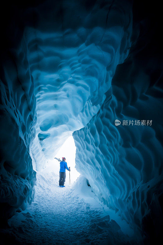 滑雪者探索冰洞。